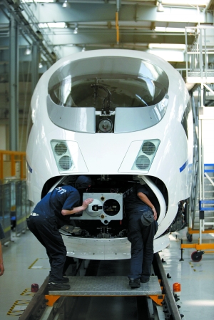 长春CRH380B生产车间，两个工人钻进车头做调试。