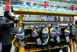 中国南车青岛四方CRH380A生产车间　工人正在设备区穿着防护服。为符合生产要求，厂房内不能使用风扇降温，一到夏天，焊接工人常汗流浃背。