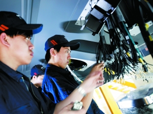 中国北车长春CRH380B生产车间　车厢底部，工人们正安装线缆。动车制造过程实行严格的质量管理措施，每个工序、环节、零件都是实名制。